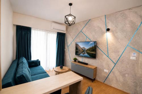 a living room with a blue couch and a table at Apartments NOCE - Premium Lake View in Ohrid