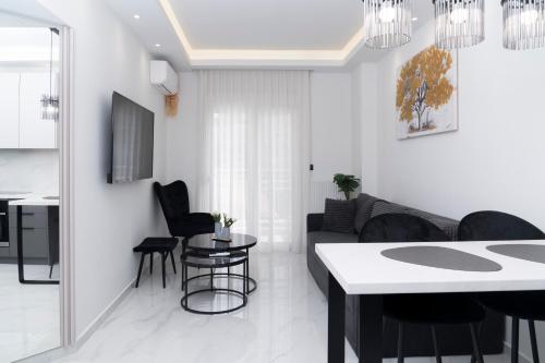 a white living room with a table and chairs at Agias Sofias Luxury Apartments in Thessaloniki