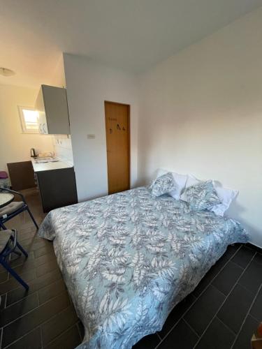 a bedroom with a bed with a blue comforter at sunny Podaca in Podaca