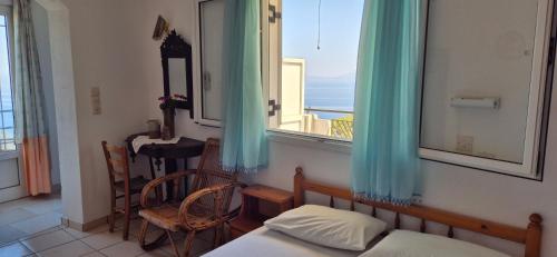 a bedroom with a window with a view of the ocean at Mary's House in Vourliótai
