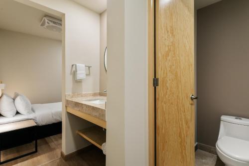 a bathroom with a toilet and a sink at Madero By Homirent in Querétaro