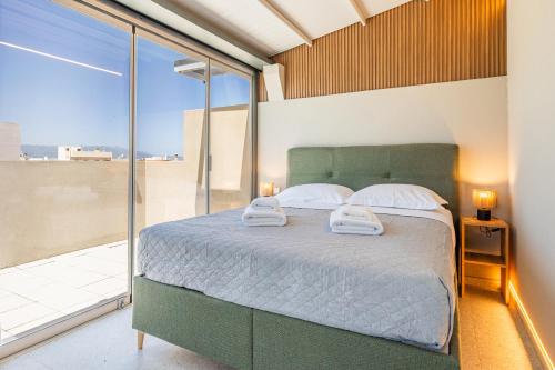 a bedroom with a bed and a large window at Raise Porta Nuova in Heraklio