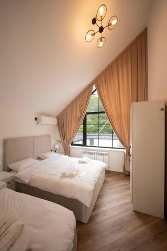 two beds in a room with a window at Quba QubaLand in Qǝlǝduz