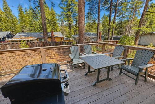 a deck with a picnic table and chairs and a grill at Chalet Near The Tahoe Keys in South Lake Tahoe