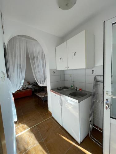 a kitchen with white cabinets and a sink at sunny Podaca in Podaca