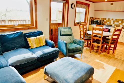 a living room with a couch and chairs and a table at Primrose Lodge with Hot Tub near Waterpark and Trails in Chudleigh