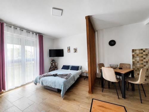 a bedroom with a bed and a table and a desk at Apartman Nati in Banja Koviljača