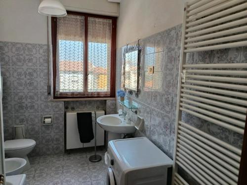 a bathroom with a sink and a toilet and window at Appartamenti Sole&Mare in Marotta