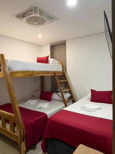 two bunk beds in a room with red sheets at Hotel Carolina Del Mar in Santa Marta