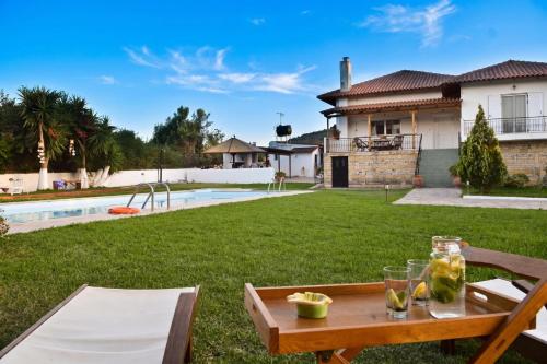 a backyard with a table with drinks on it at Villa John Dimeon Kato Achaia With Pool - Happy Rentals in Patra