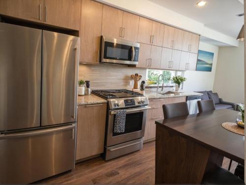 a kitchen with a stainless steel refrigerator and a table at Premier Downtown Koreatown Apartment in Los Angeles