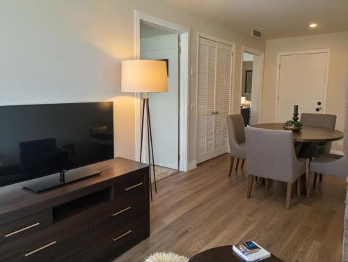 a living room with a dining room table and a television at Premier Downtown Koreatown Apartment in Los Angeles