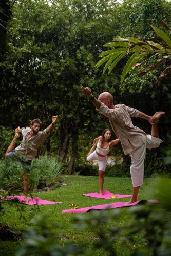 a man and a woman are standing on mats in the grass at Mision del Sol Resort & Spa Adults Only in Cuernavaca