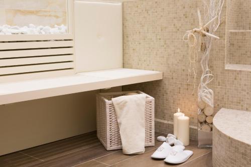 a bathroom with a towel shelf and two candles at Hotel Feldberg in Riccione