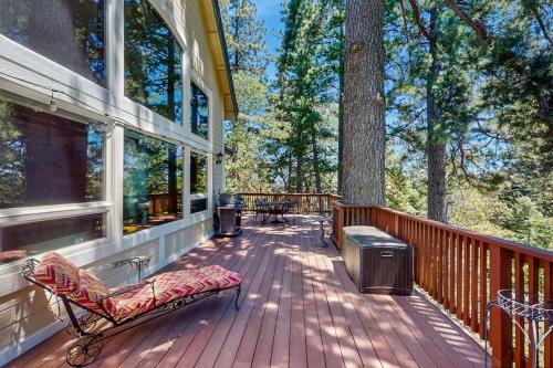a porch of a house with a bench and a grill at Summit Sanctuary in Lake Arrowhead