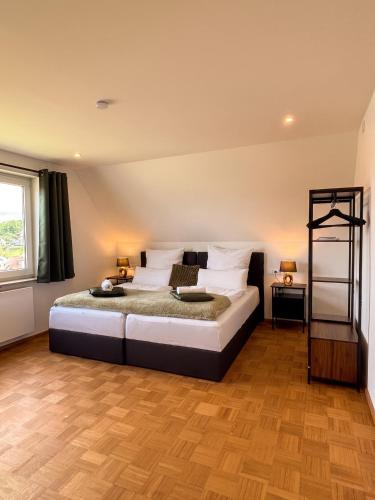 a bedroom with a large bed and a window at Deluxe Apartment in Jettingen-Scheppach