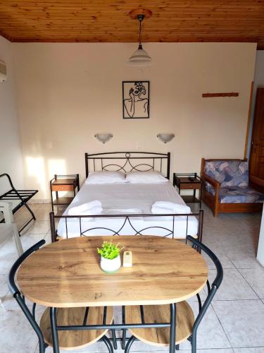 a bedroom with a bed and a wooden table at Hector's Studios in Alikanas