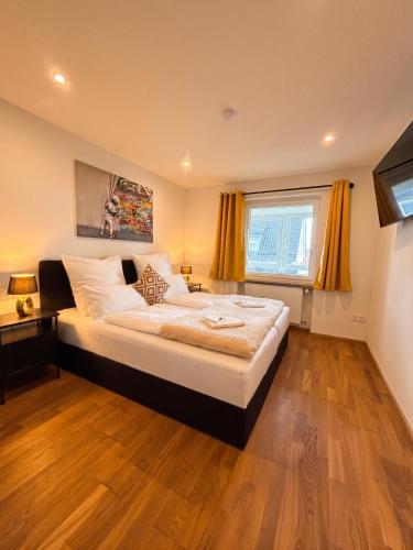 a bedroom with a large bed and a window at Moderne Ferienwohnung in Jettingen-Scheppach