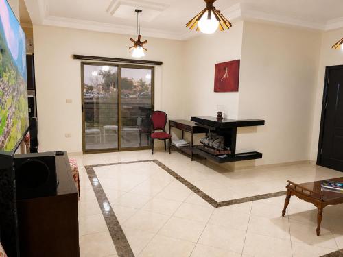 a living room with a desk and a chair at Cozy Central Secured Compound in Amman