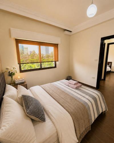 a bedroom with a large bed with a window at Cozy Central Secured Compound in Amman