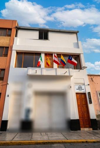 a building with several flags on the side of it at SANCA HOUSE Hostel in Trujillo