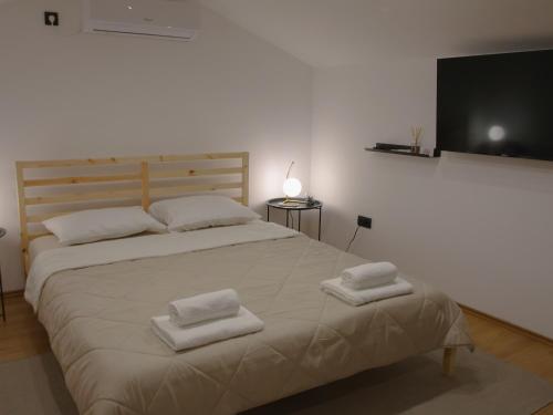 a bedroom with a large bed with two towels on it at Rentalica in Belgrade