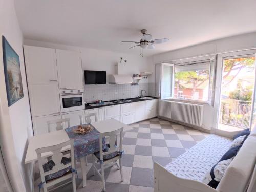 a kitchen with white cabinets and a table and a window at Maréthias in Punta Marina