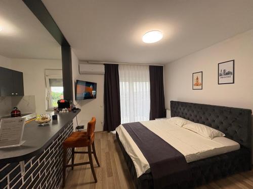 a bedroom with a bed and a desk in it at Infinit Apartment in Prishtinë