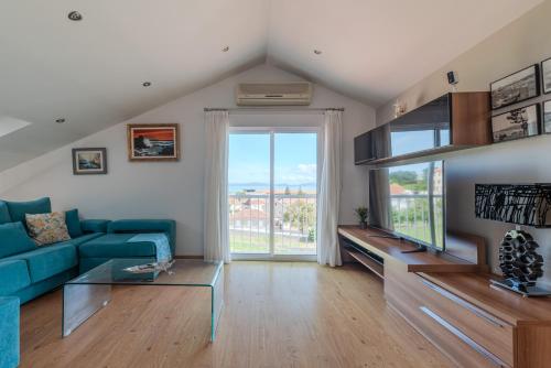a living room with a blue couch and a large window at Atico Solpor Patos in Nigrán