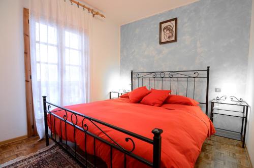 sypialnia z dużym łóżkiem z czerwonymi poduszkami w obiekcie Appartamenti Il Sogno w mieście Campodolcino