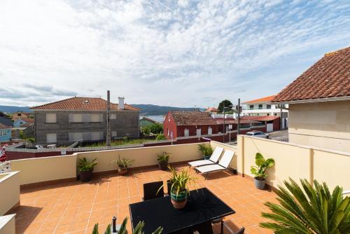 a balcony with a table and chairs on a roof at Atico Solpor Patos in Nigrán