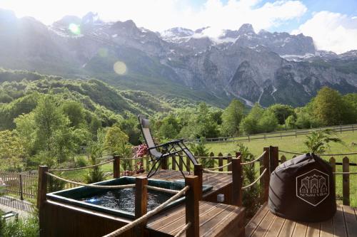 a hot tub on a deck with a view of mountains at SeSam Villas in Theth