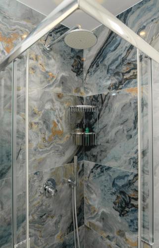 a bathroom with a shower with a marble wall at Villa Markiani in Aegiali