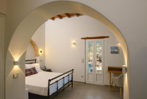 a bedroom with a bed and an archway at Villa Markiani in Aegiali