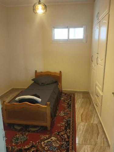 a bedroom with a bed with a rug and a window at Maison ras angela in Bizerte