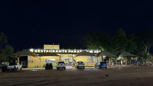 a restaurant with cars parked in a parking lot at night at Hotel Parada KM364 in Santo Antonio do Rio Abaixo