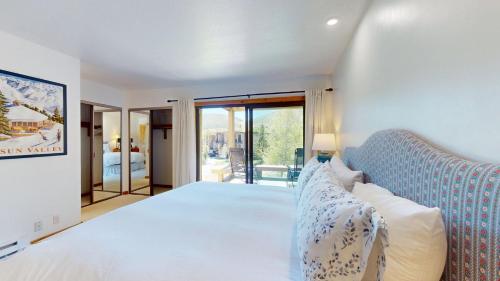 a bedroom with a large white bed and a balcony at Ridge Condo 2610 in Sun Valley
