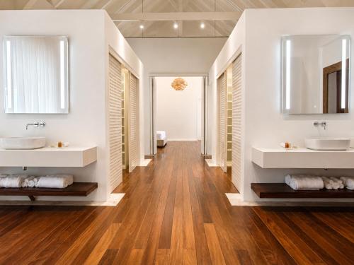 a bathroom with two sinks and two mirrors at Miara - Celebrity villa in Casa de Campo! in La Romana