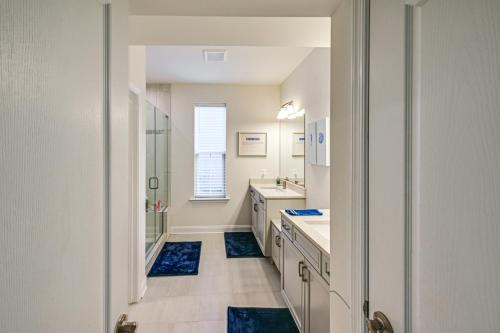 a bathroom with two sinks and a shower and a mirror at Beach Shuttle! Spacious Bishop’s Landing Retreat in Ocean View