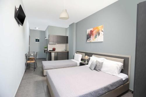 a hotel room with two beds and a kitchen at Soluna Studios in Polychrono