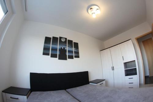 sypialnia z łóżkiem i białą ścianą w obiekcie Urban Apartman w Miszkolcu