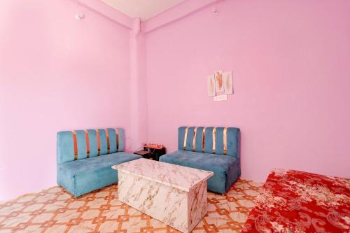two chairs and a table in a room with pink walls at SPOT ON S.S HOTEL in Lucknow