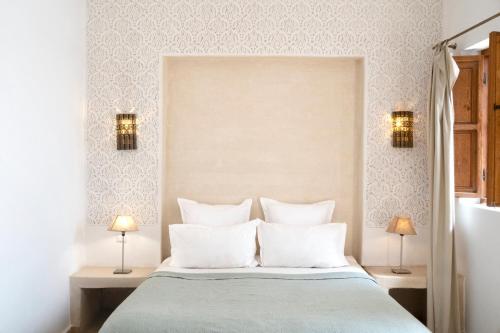 a bedroom with a large bed with two lamps at Riad Lamzia in Marrakesh