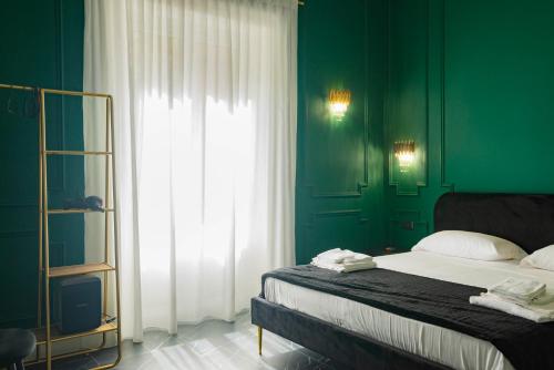 a green bedroom with a bed and a window at Four Rooms Luxury Suite in Palermo