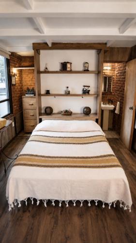 a bedroom with a large white bed with wooden floors at Hotel Frida in Mexico City