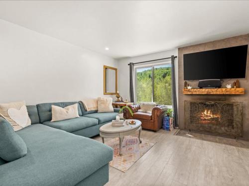 a living room with a blue couch and a fireplace at G125 by SkyRun Aspen in Snowmass Village