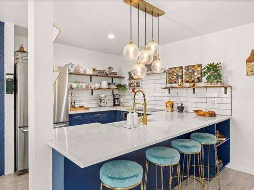 a kitchen with blue cabinets and a counter with stools at G125 by SkyRun Aspen in Snowmass Village