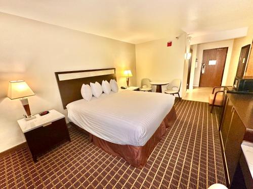 a hotel room with a large bed with white sheets at Alhambra Hotel in Alhambra