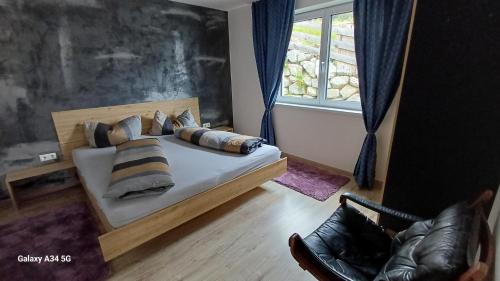 a bedroom with a bed with pillows and a window at Sunhill Apartamente in Karrösten