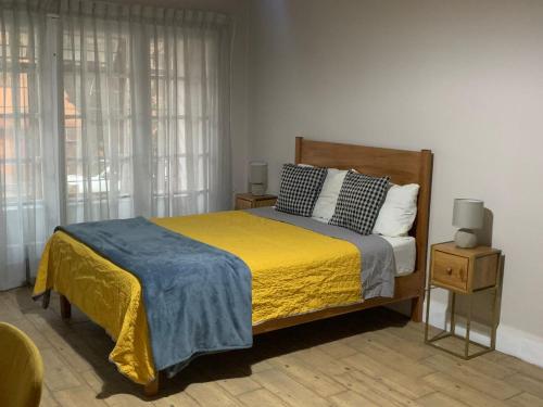 a bedroom with a large bed with a yellow blanket at Rio amazonas 7 in Mexico City